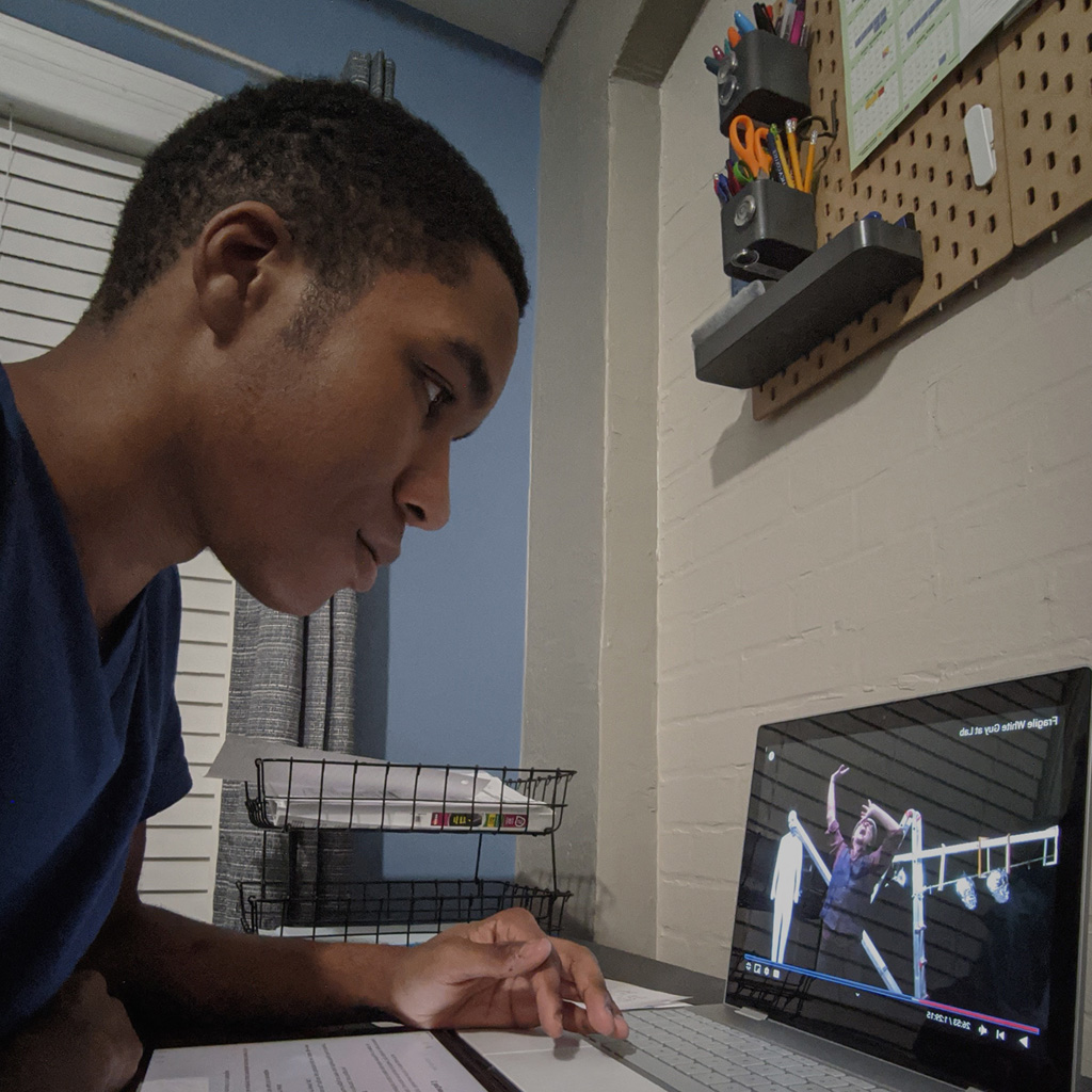 Pre-college student watches a video while in his Summer College program