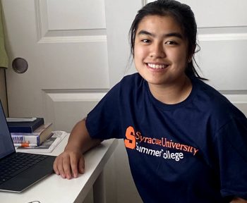 A student wearing a t-shirt that says Syracuse University Summer College