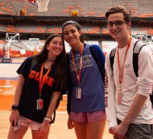 Three high school students on the basketball court at Syracuse University