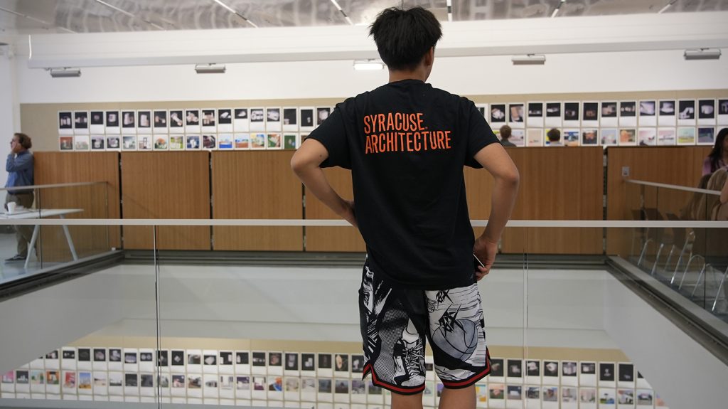 A Summer College student examines the architecture class final exhibition.