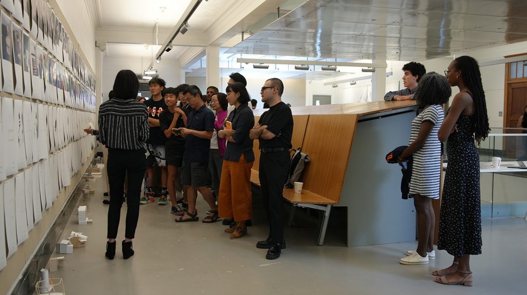 Summer college students examine the architecture class final exhibition.