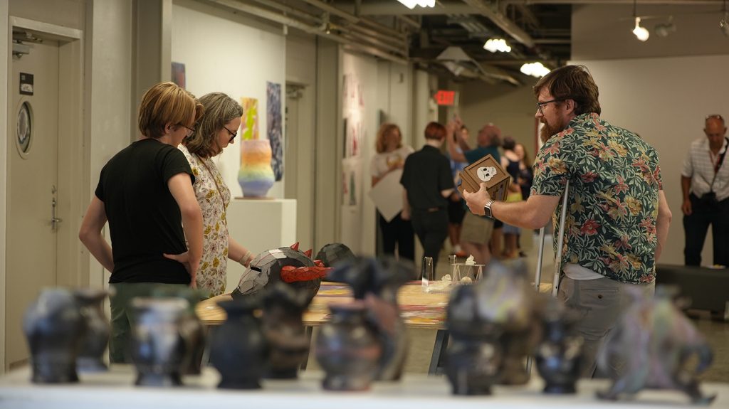 People examine the art academy final exhibition.