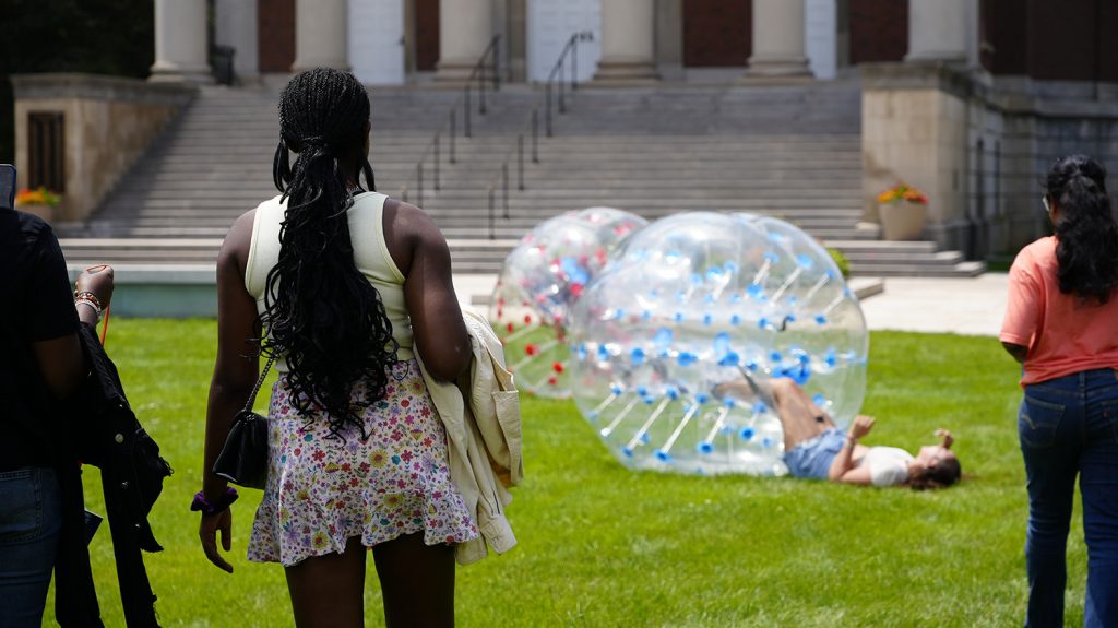 Summer College students play with inflatable bumper balls on the quad. 