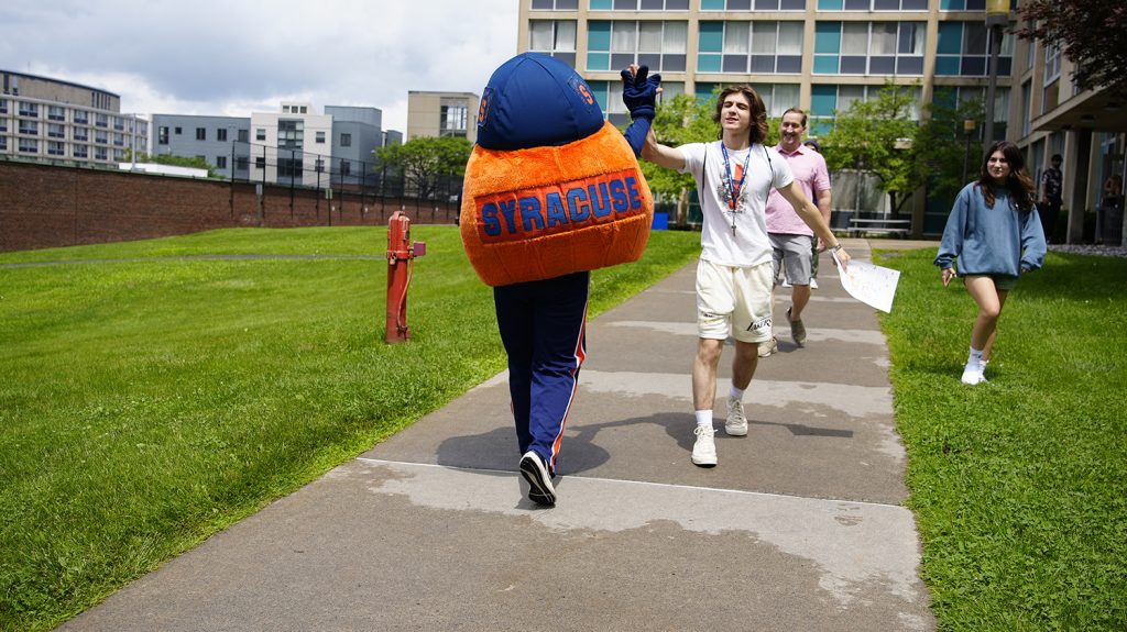 Otto high fives a Summer College student during move-in. 