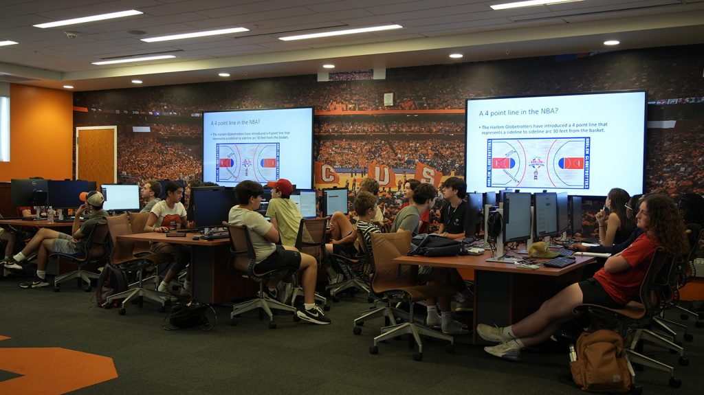 Summer College students analyze sports analytics. 
